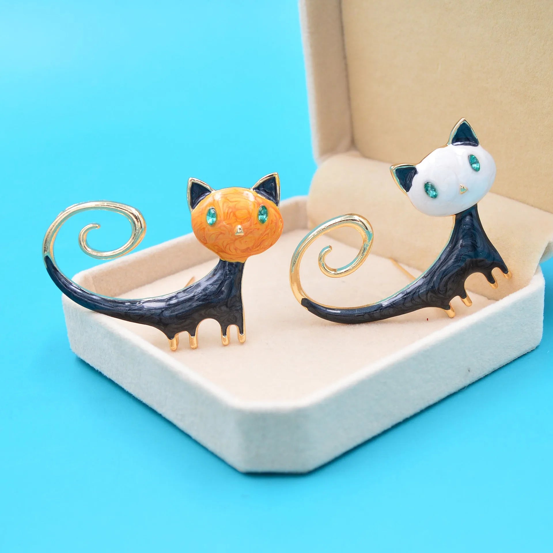 Orange and white alloy brooch with painted design of a cat with its tail up.