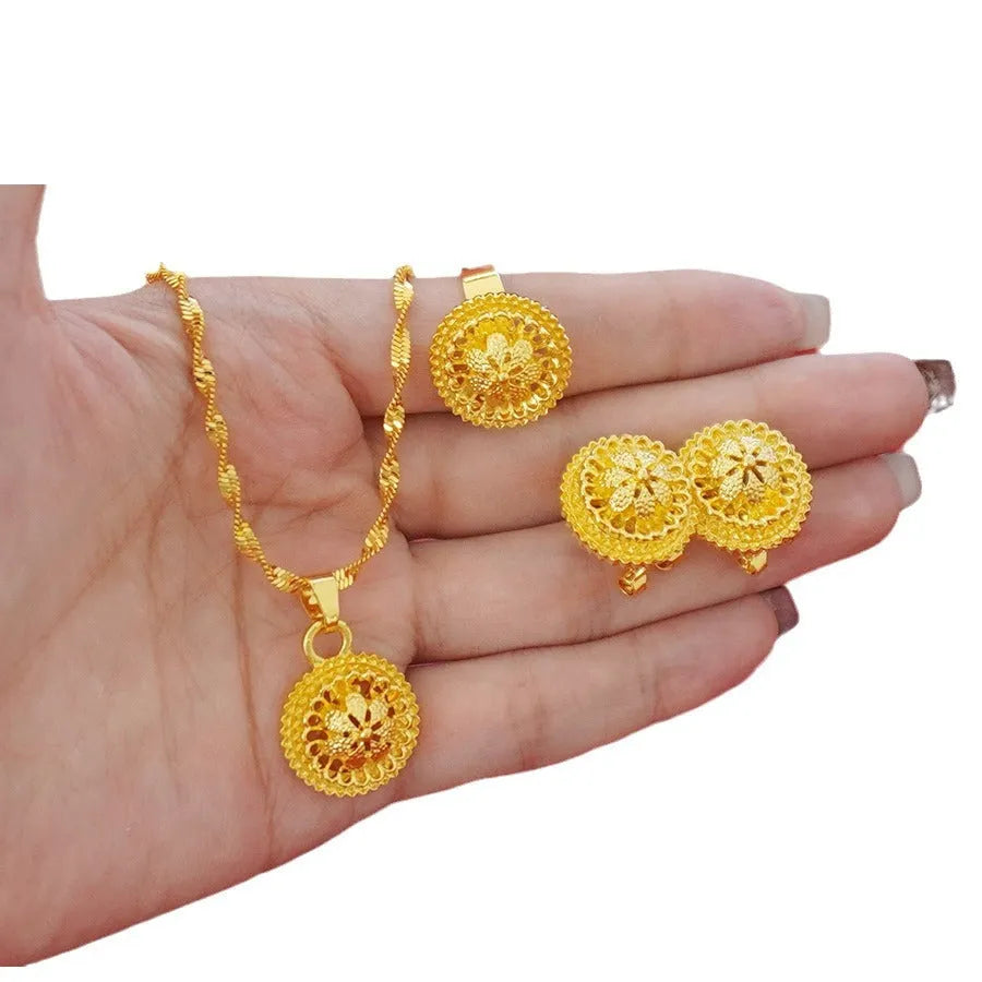 Gold-plated three-piece jewelry set showing necklace, earrings, and ring with a detailed flower design pendant.