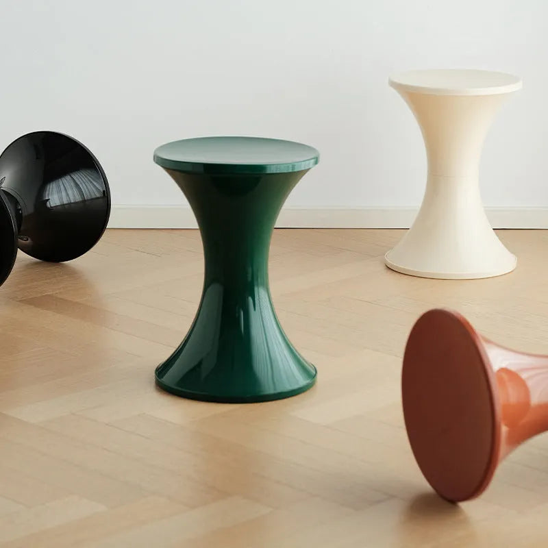 A plastic hourglass-shaped stool for changing shoes, shown in one of five available colours.