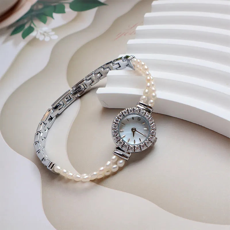Women's light gold bracelet watch with freshwater pearl accents and round 18mm dial