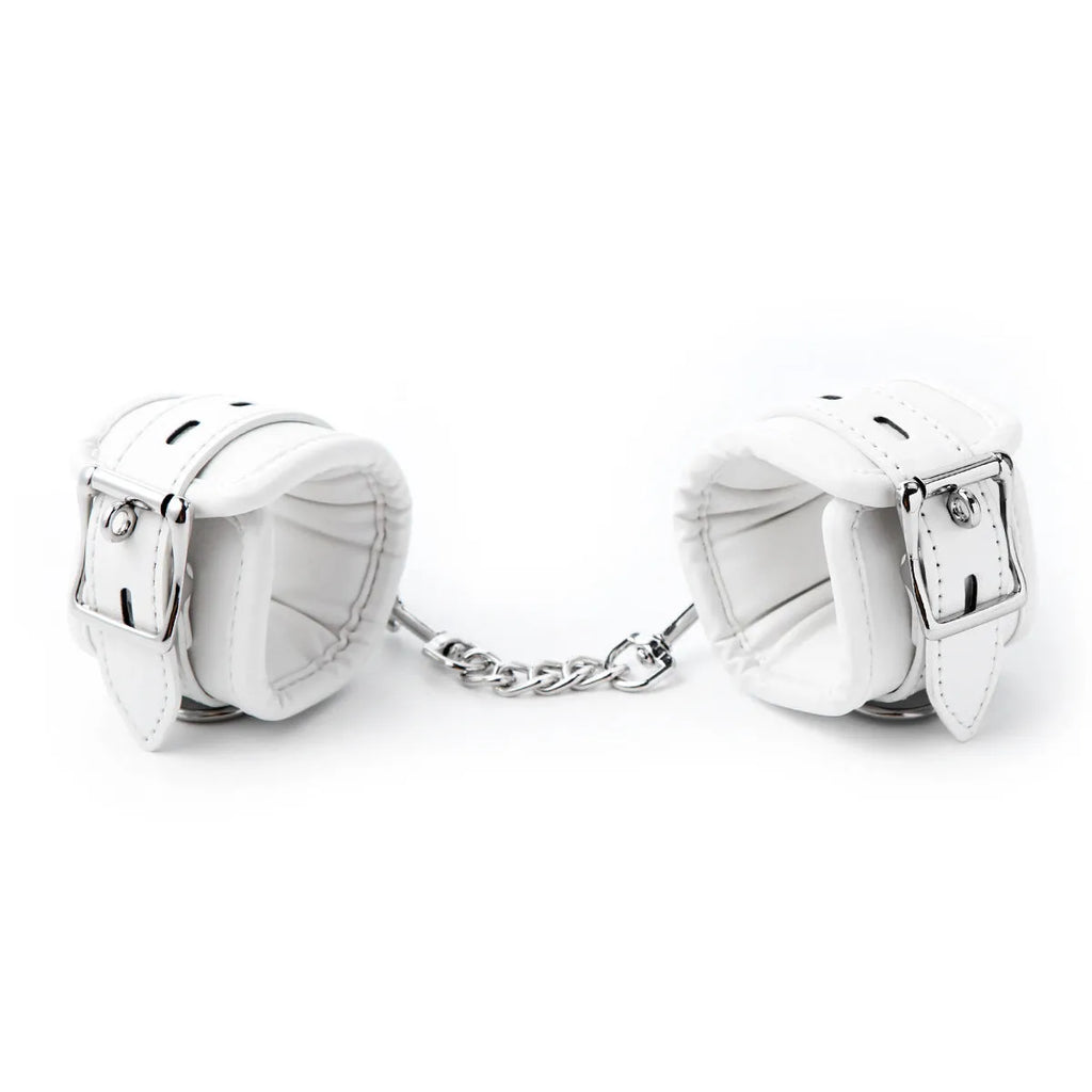 White PU sponge sex toy bondage kit showing handcuffs, foot cuffs, and a neck scarf arranged together.