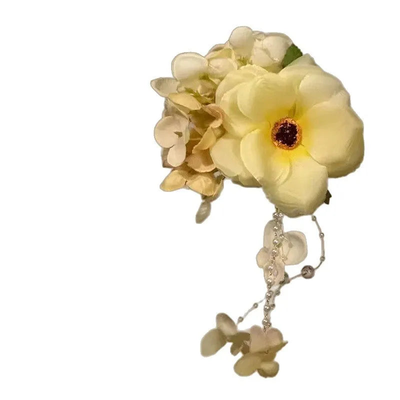 Yellow flower tassel hair clip with pearl and linglan elements on white background