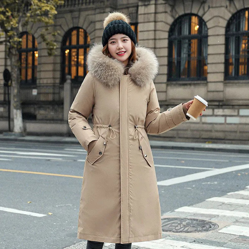 Women's long beige trench coat with fleece lining on a hanger, showing its extended length and elegant style.