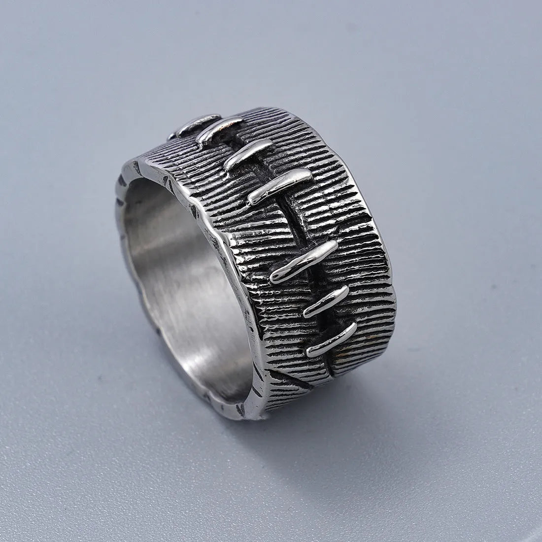 Dark punk geometric U-shaped double ring in titanium steel on a solid background