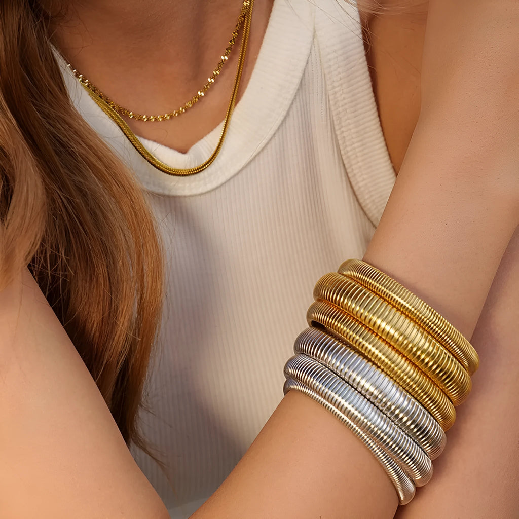 Gold titanium steel women's bracelet with elastic band and vertical stripe ring pattern, shown at 2cm width.