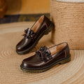 Black women's leather shoes with chunky flat heel, round toe, and low-top design on a plain background.