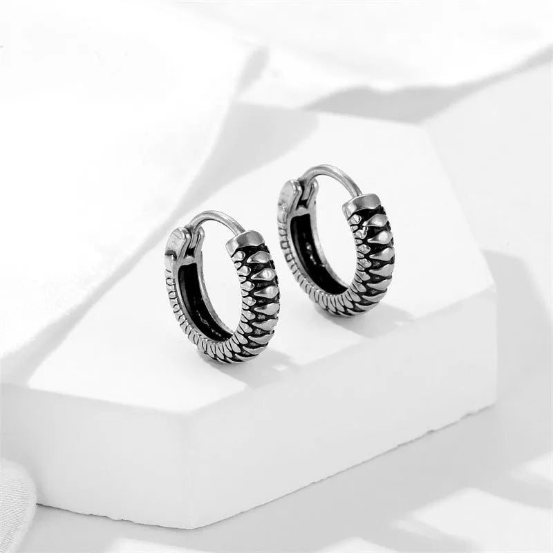 Silver geometric stainless steel earrings with a twist and striped design on a white background.