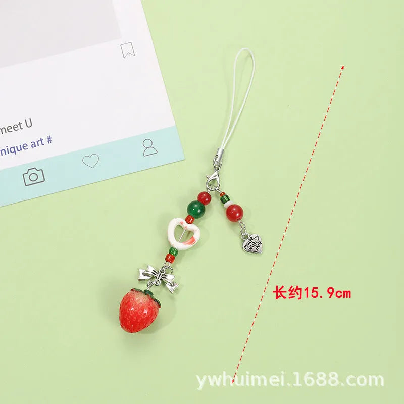 Plastic resin fruit charm keychain with removable rope in strawberry, green apple, and red apple designs.