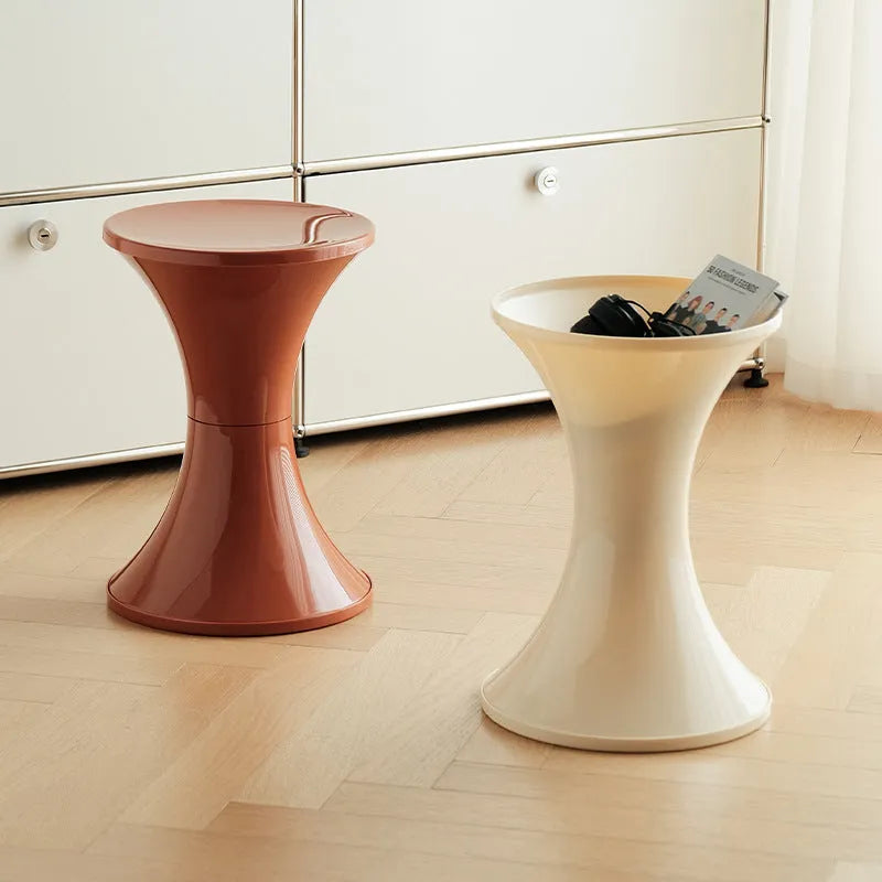 A plastic hourglass-shaped stool for changing shoes, shown in one of five available colours.