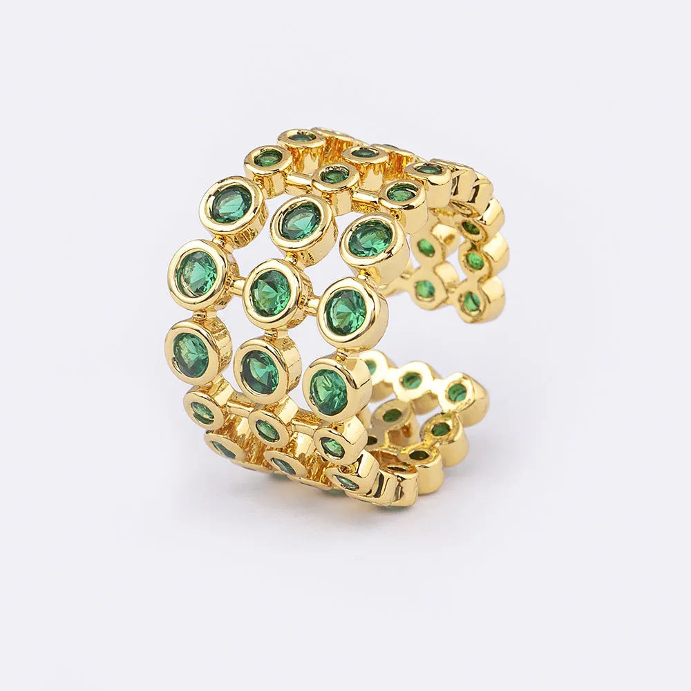 Close-up of a wide gold-plated ring with a large emerald-cut green zircon stone in a three-layer unisex design.