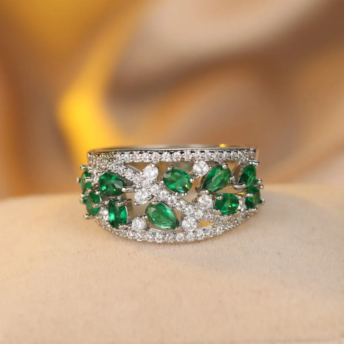 Women's round hollow fashion ring with gemstone accents on a copper band, shown in gold and platinum finishes.