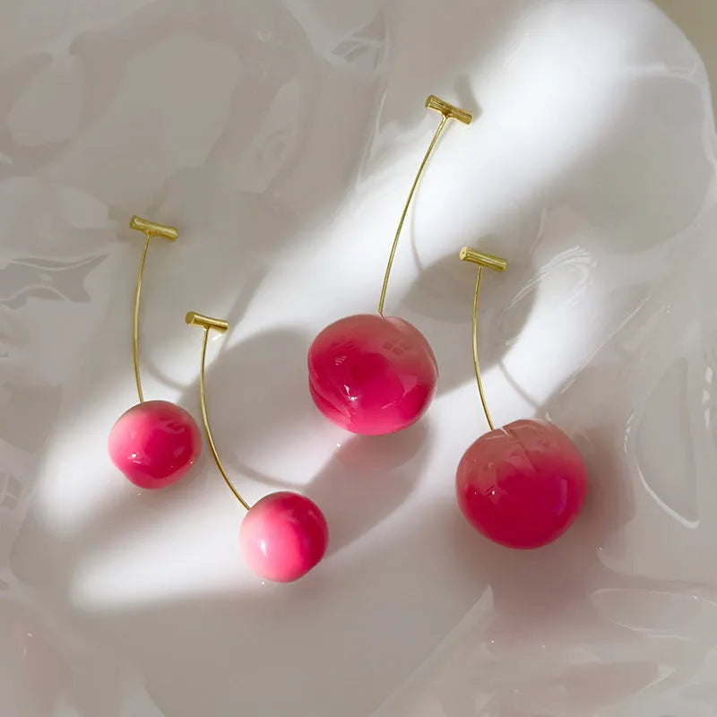 Acrylic peach-shaped dangle earrings with copper findings, shown in small and large size variations.
