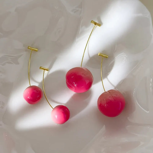 Acrylic peach-shaped dangle earrings with copper findings, shown in small and large size variations.