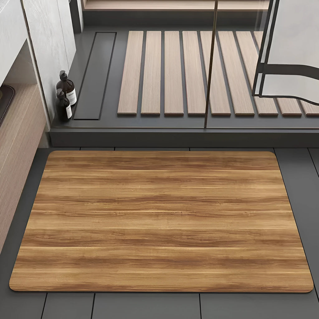 Square diatomite bathroom floor mat with geometric print in a wood grain colour on a tiled floor.