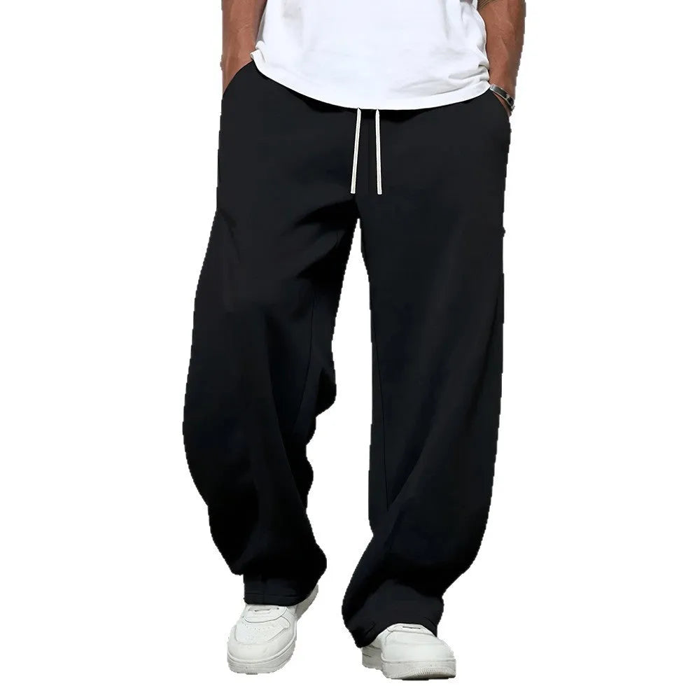 Men's solid colour straight-leg casual trousers with a drawstring waist on a hanger.