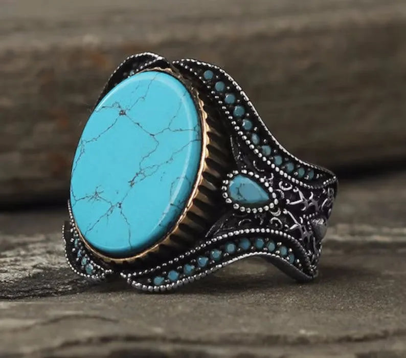 Men's antique silver alloy ring with a round turquoise-coloured centre on a grey background.