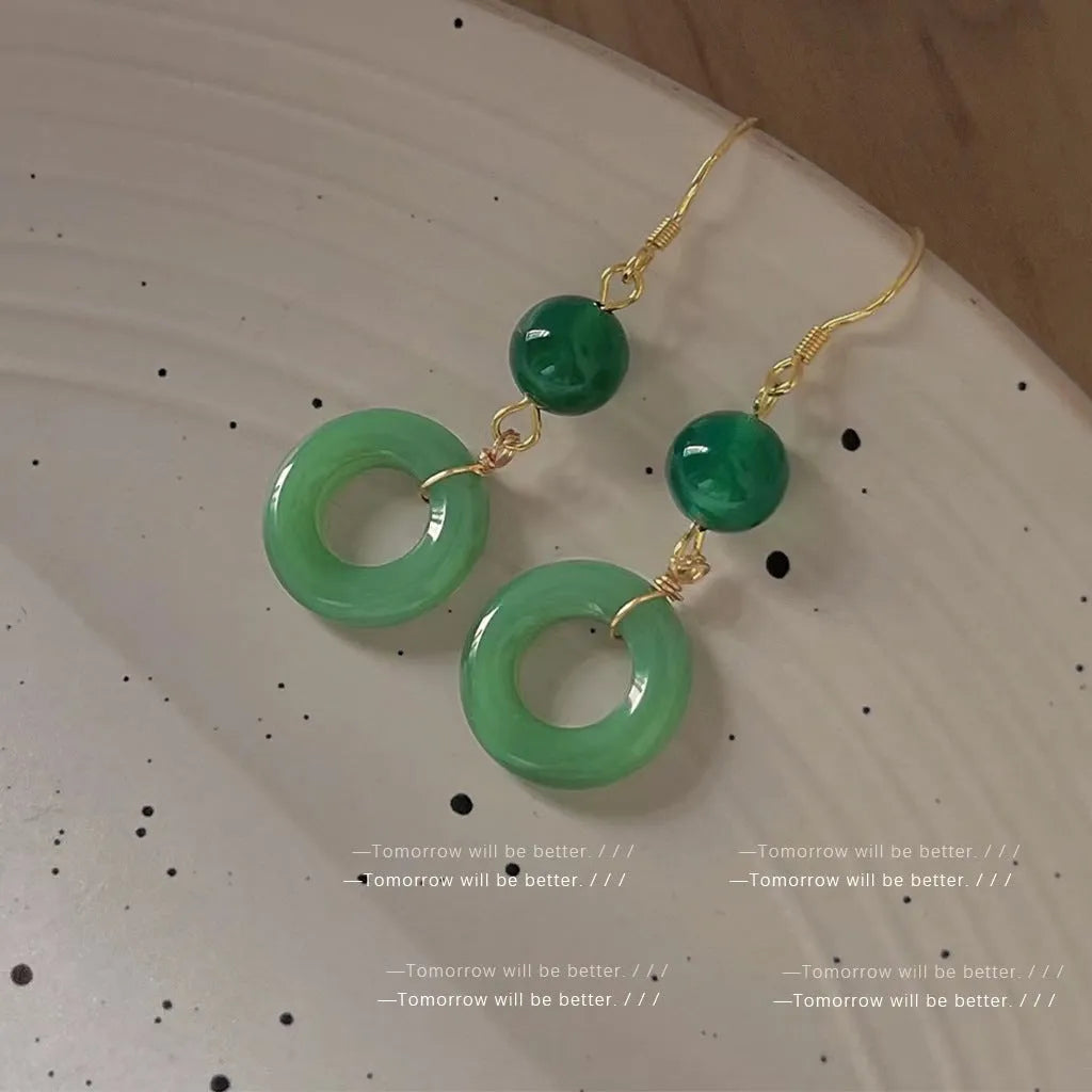 A pair of green geometric Peace Buckle-shaped earrings inspired by traditional Chinese cheongsam design.