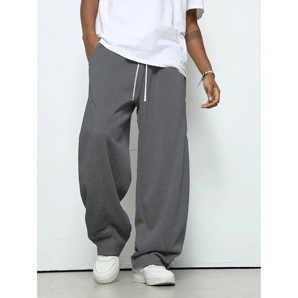 Men's solid colour straight-leg casual trousers with a drawstring waist on a hanger.
