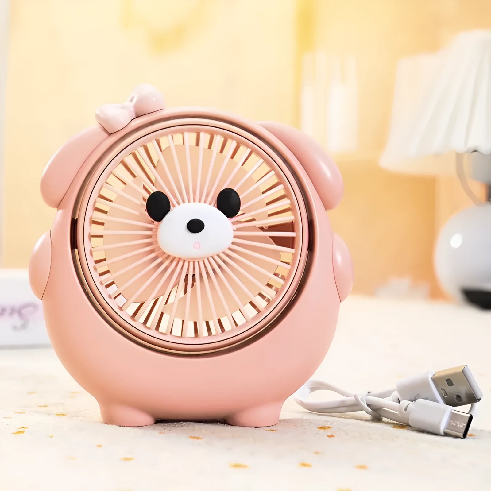 USB desktop electric fan in one of six colours including bear brown and puppy designs on a desk.