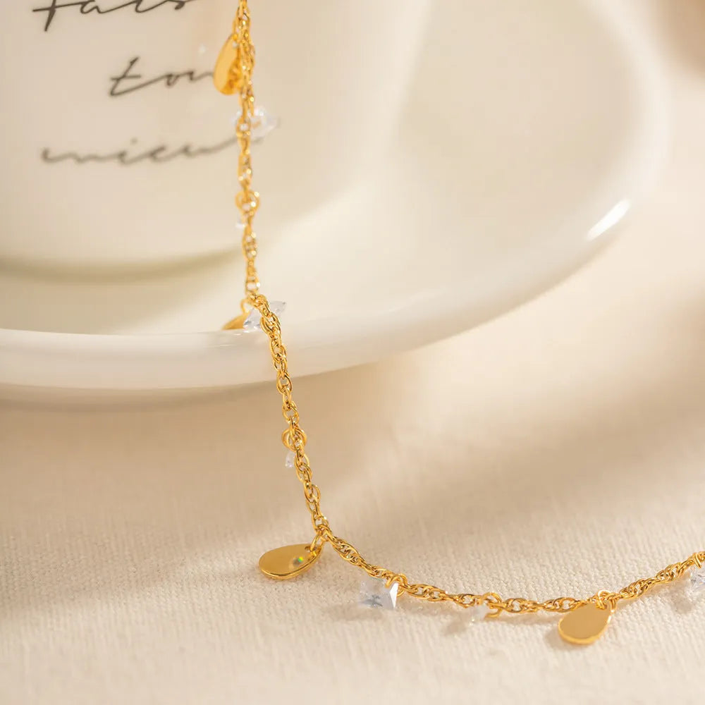 Women's stainless steel geometric anklet with water drop pendant and tassel detailing