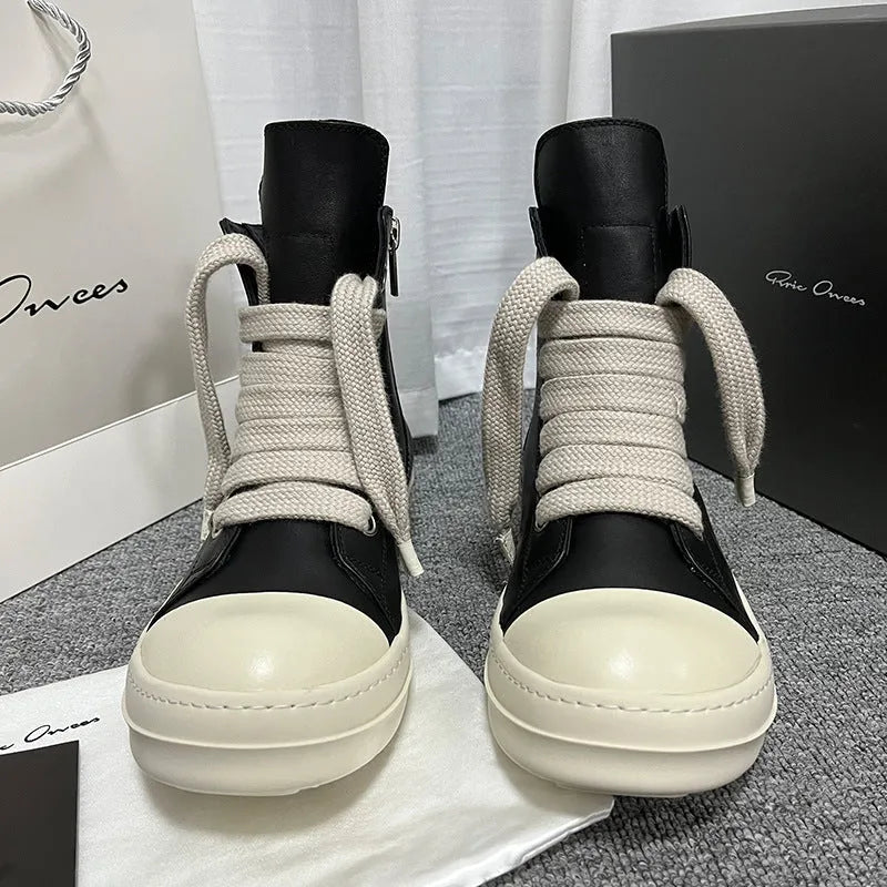 Black high-top leather sneakers with side zipper on a white background.