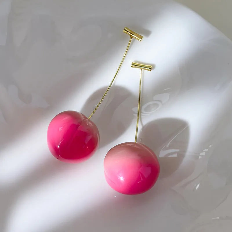 Acrylic peach-shaped dangle earrings with copper findings, shown in small and large size variations.