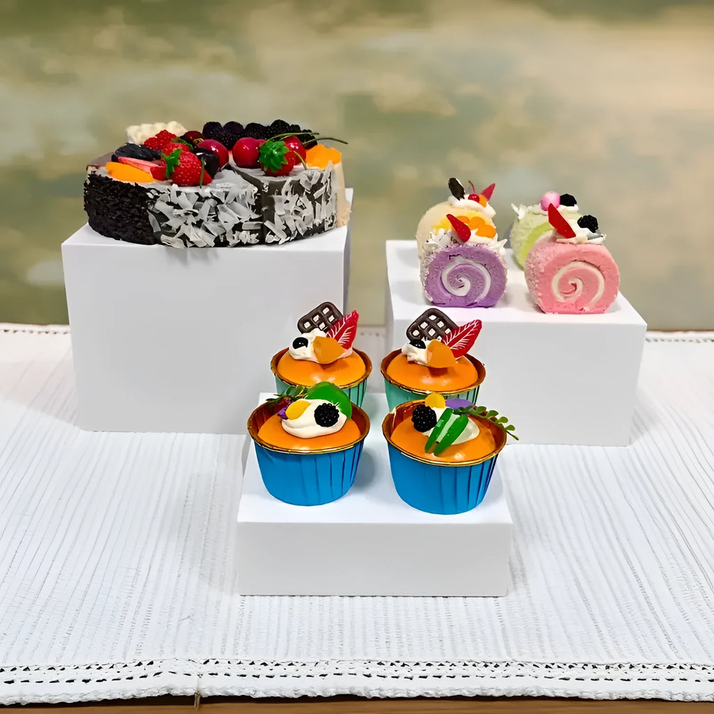White plastic cube dessert display stand with six modular pieces arranged on tabletop