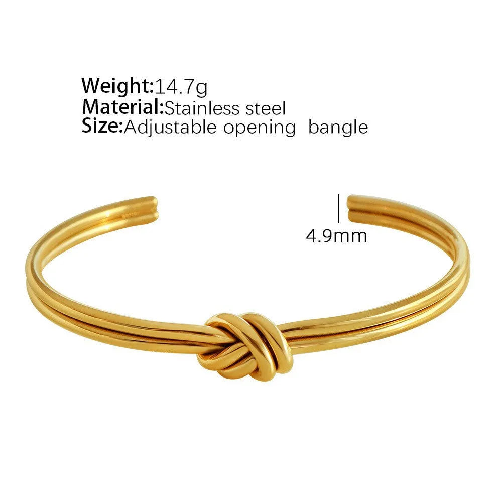 Open C-shaped stainless steel bracelet with knotted double layer design in gold or silver finish.