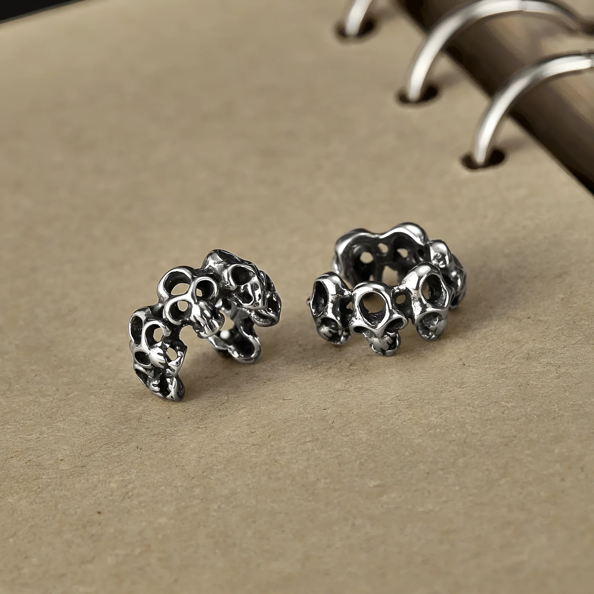 Steel hollow skull earrings with geometric design and ear clip fitting