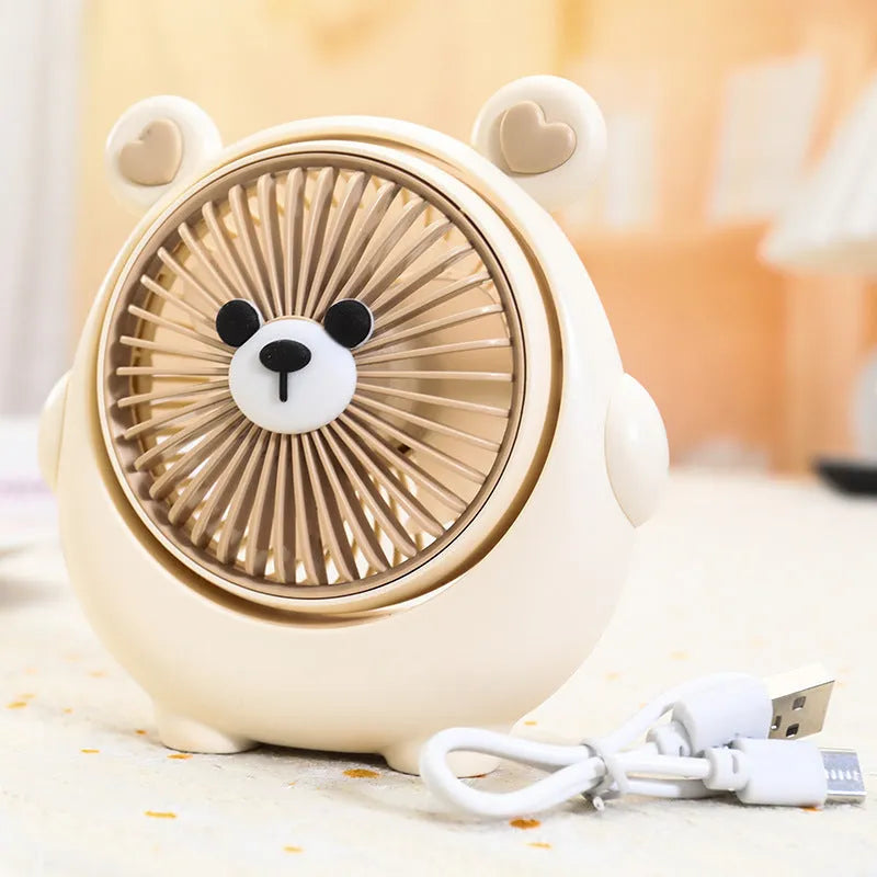 USB desktop electric fan in one of six colours including bear brown and puppy designs on a desk.