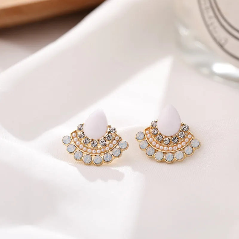 Silver fan-shaped drop earrings with rhinestone and opal geometric design on white background