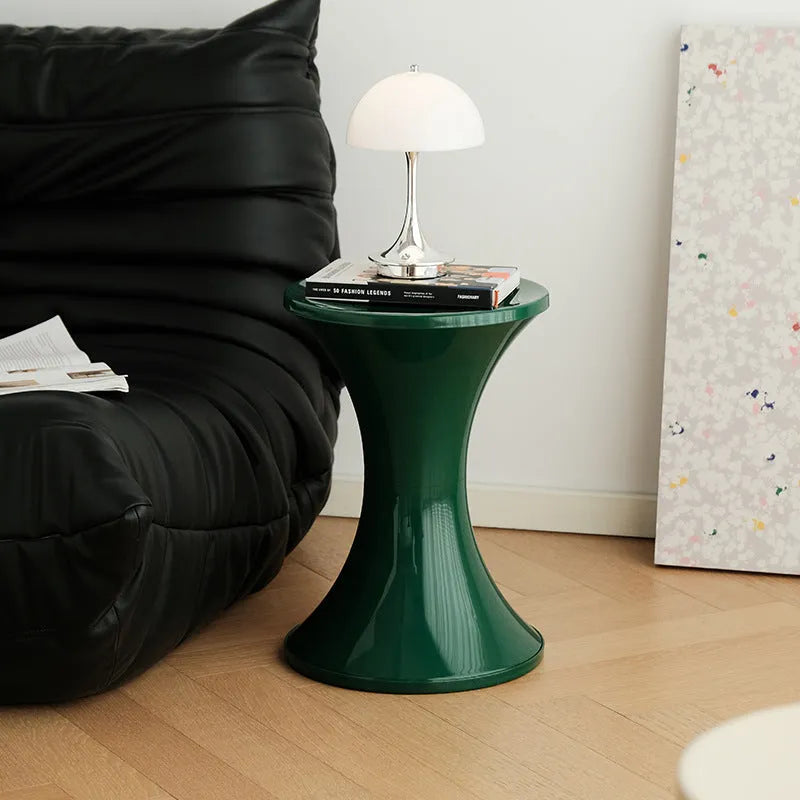 A plastic hourglass-shaped stool for changing shoes, shown in one of five available colours.