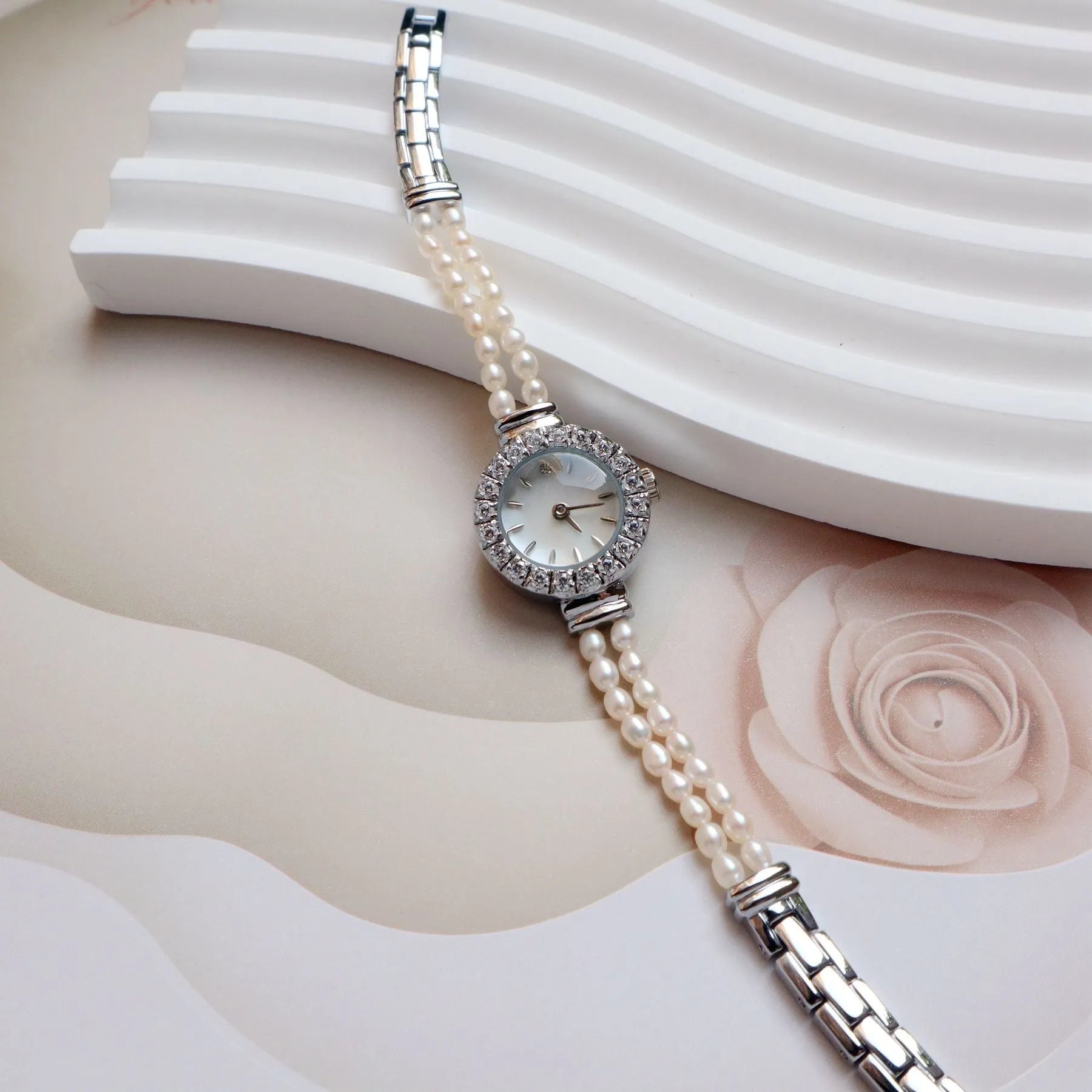Women's light gold bracelet watch with freshwater pearl accents and round 18mm dial