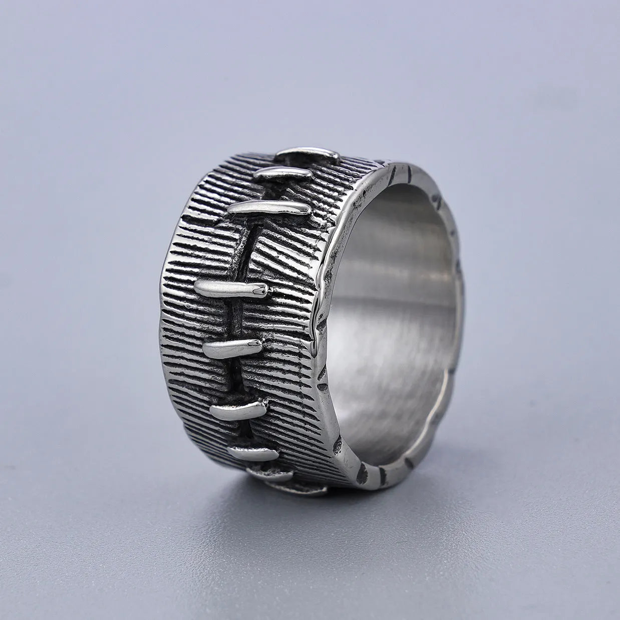 Dark punk geometric U-shaped double ring in titanium steel on a solid background