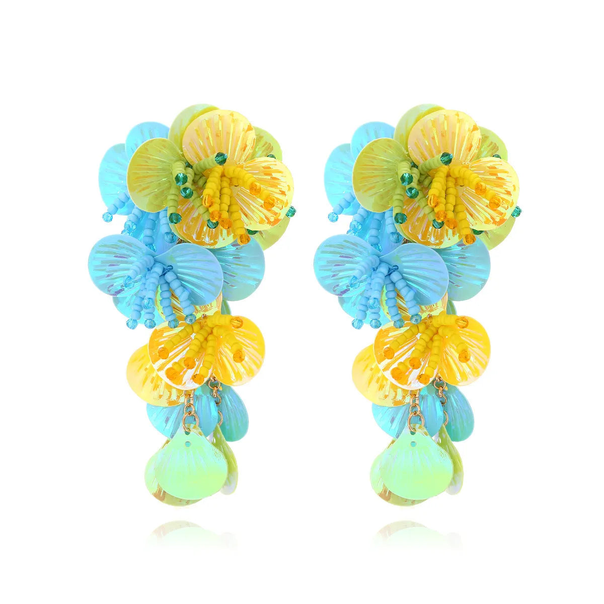 Handmade exaggerated floral earrings with colourful string beads and leaves on a purple background.