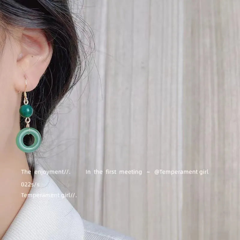 A pair of green geometric Peace Buckle-shaped earrings inspired by traditional Chinese cheongsam design.