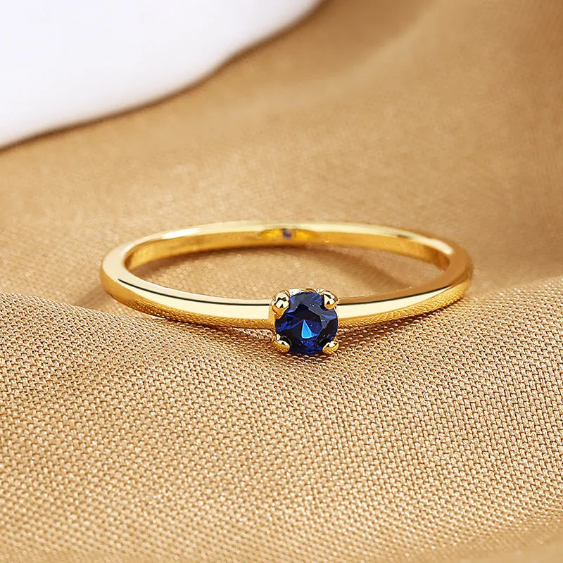 Women's copper fine circle ring with a single diamond in a geometric setting, shown on a hand.