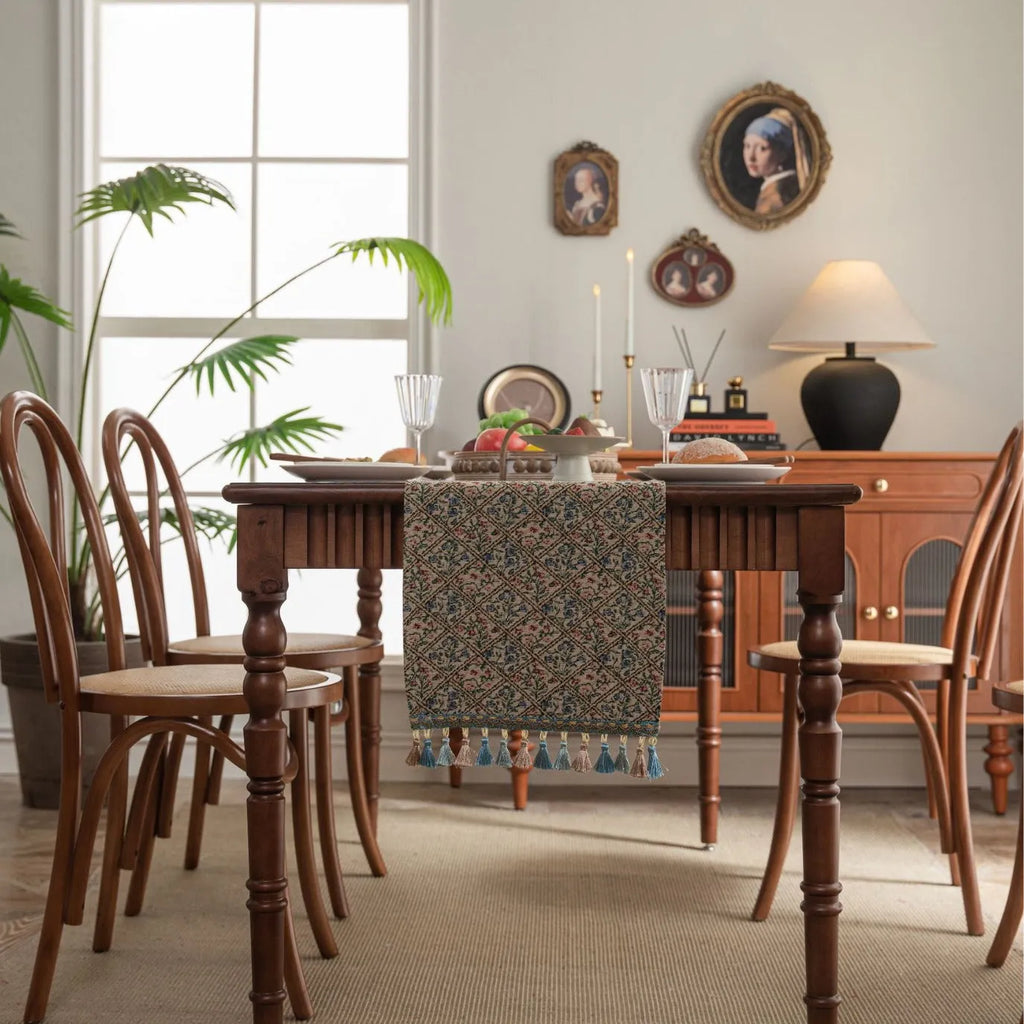 Dark blue Nordic Jacquard table runner with bouquet design and tassels laid on a wooden table.