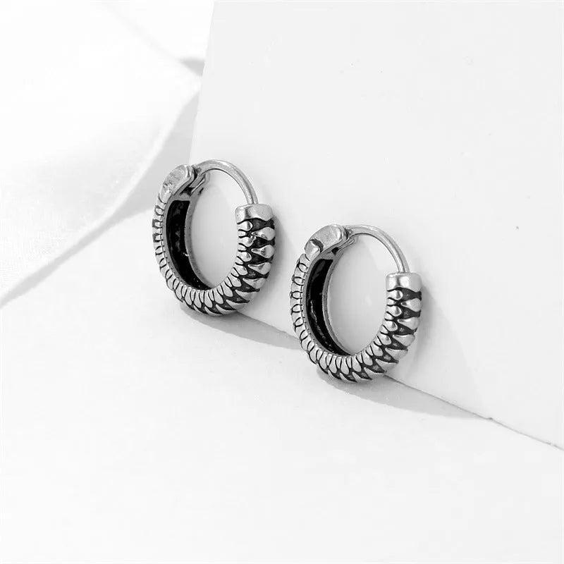 Silver geometric stainless steel earrings with a twist and striped design on a white background.