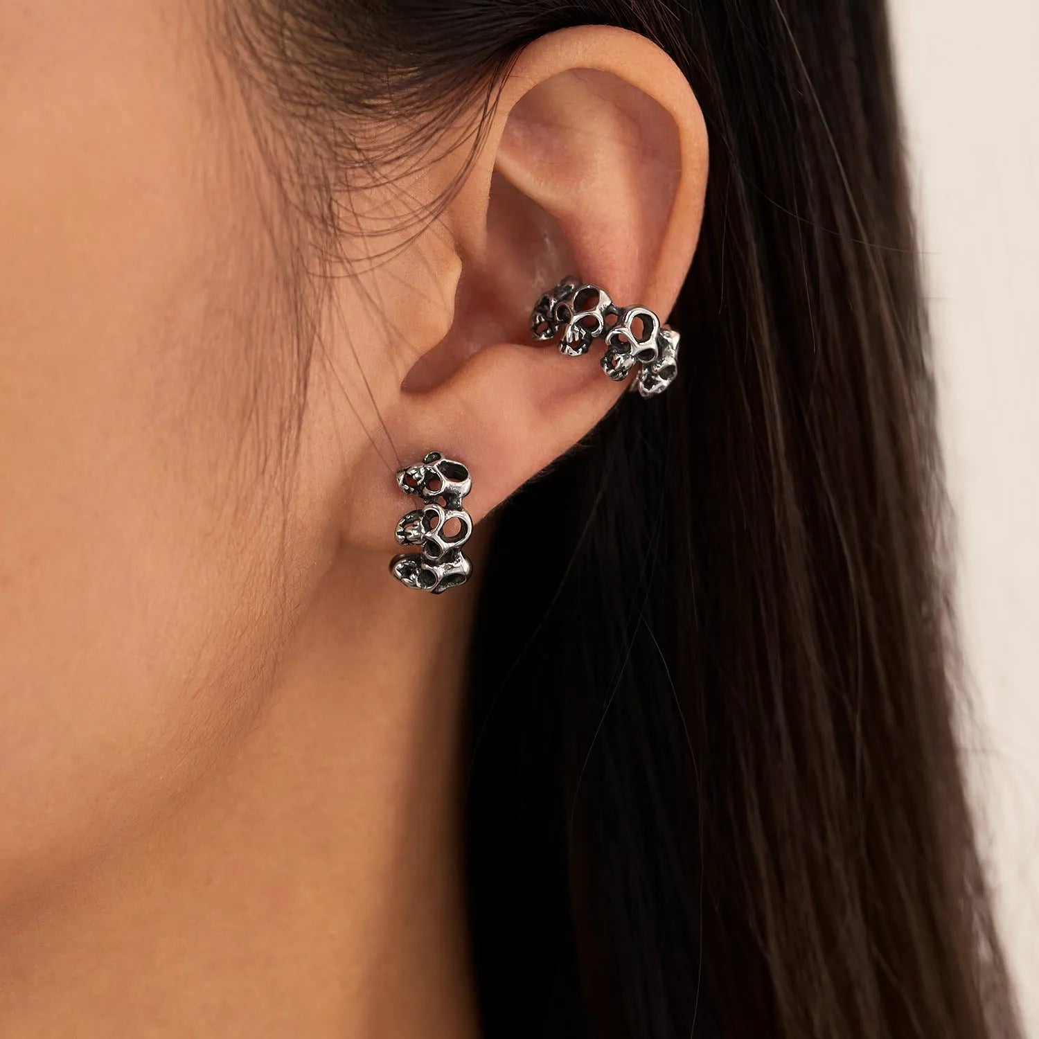 Steel hollow skull earrings with geometric design and ear clip fitting