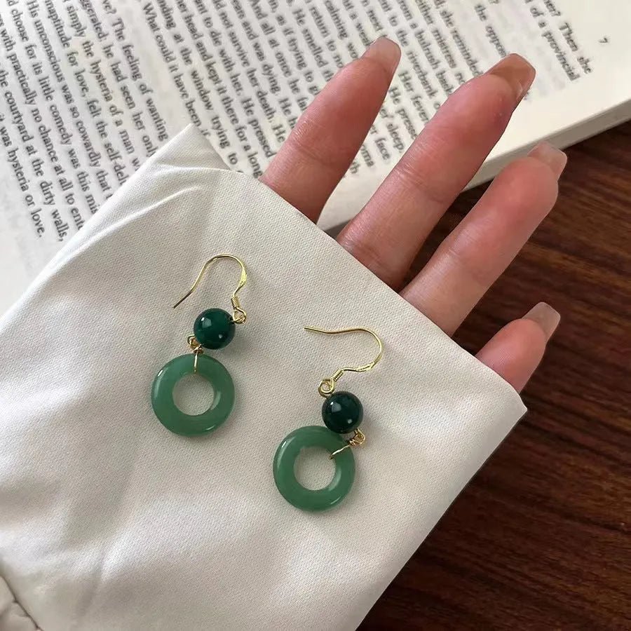 A pair of green geometric Peace Buckle-shaped earrings inspired by traditional Chinese cheongsam design.