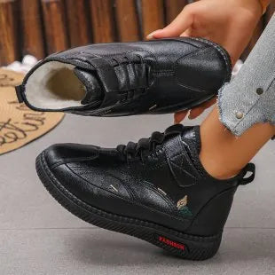 Women's black velvet low-cut indoor slippers with a non-slip rubber sole and decorative hollow out details.