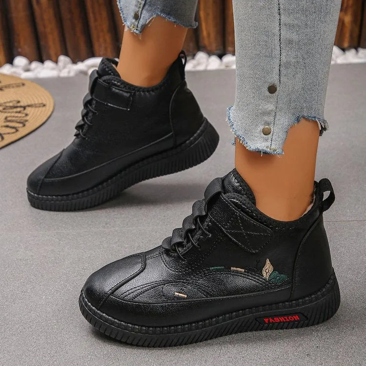 Women's black velvet low-cut indoor slippers with a non-slip rubber sole and decorative hollow out details.