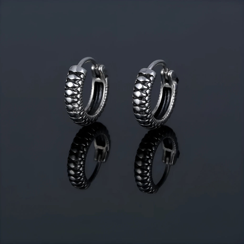 Silver geometric stainless steel earrings with a twist and striped design on a white background.