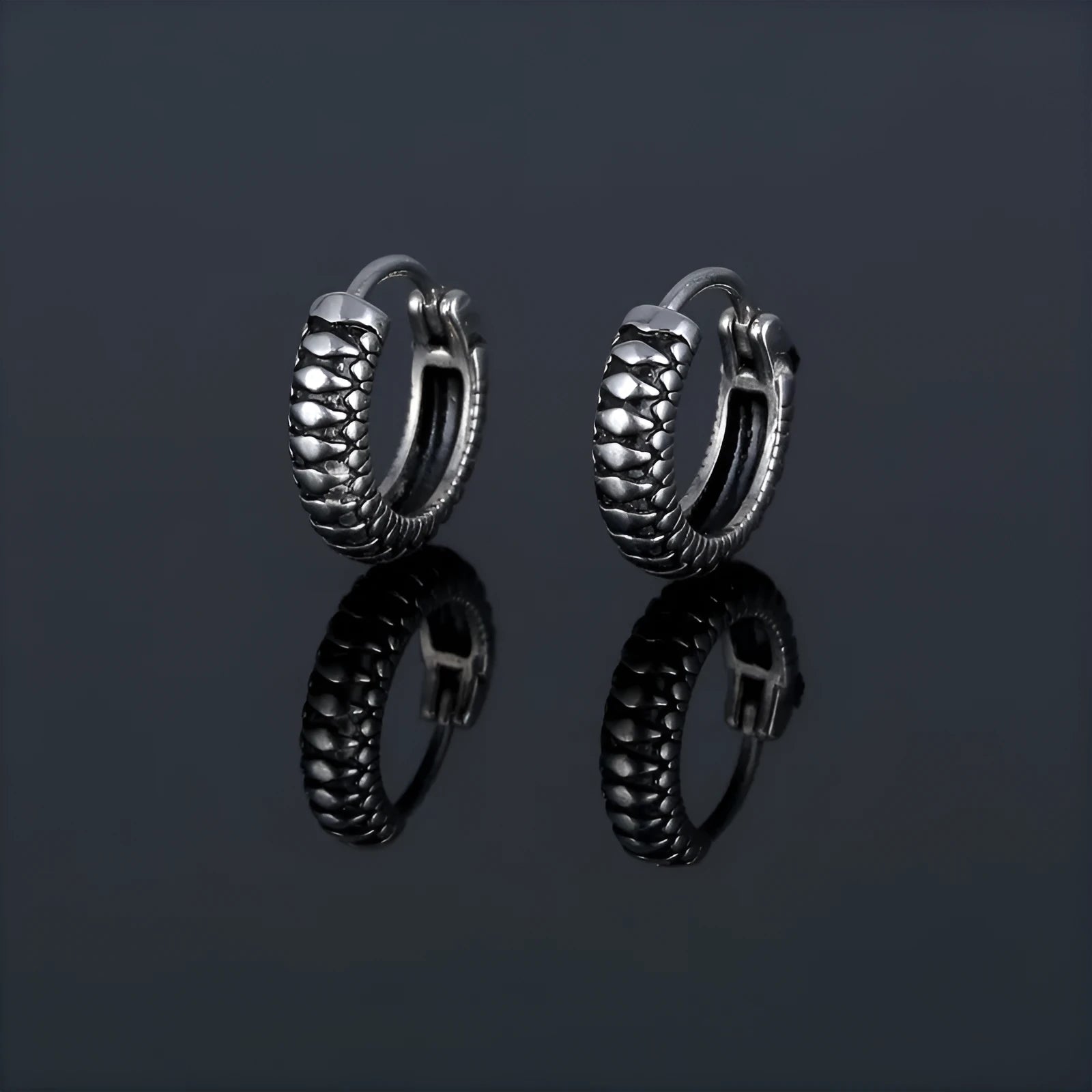 Silver geometric stainless steel earrings with a twist and striped design on a white background.
