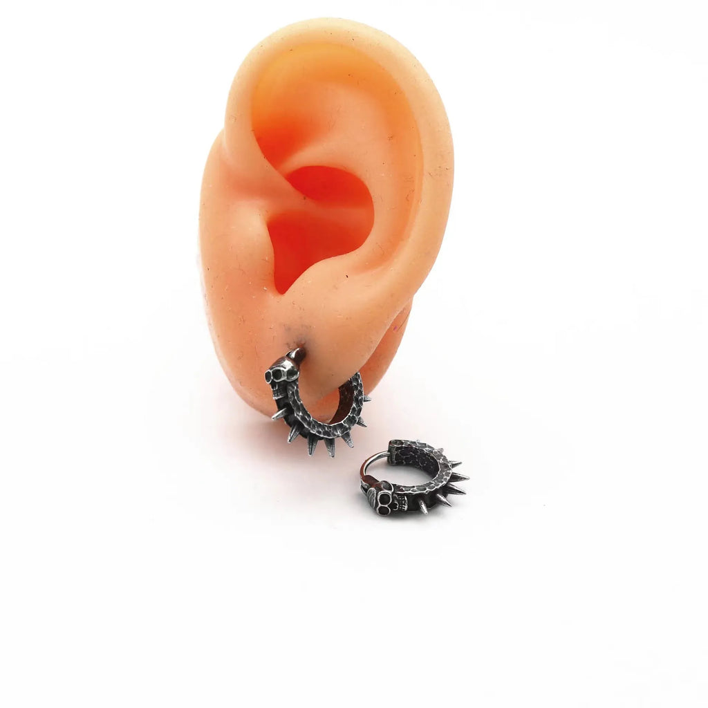 A pair of black alloy earrings with a geometric motorcycle punk design on a white background.