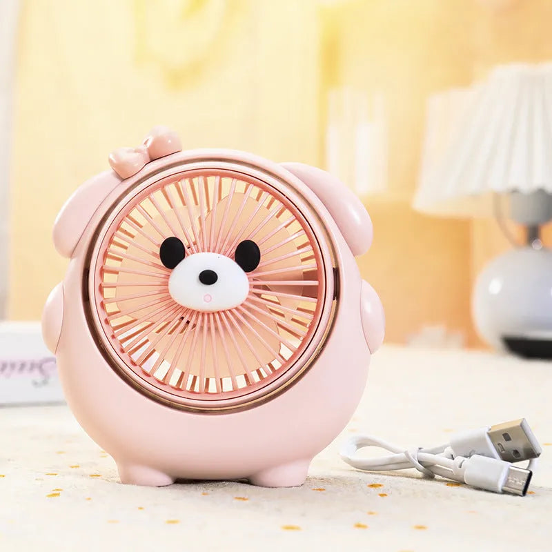 USB desktop electric fan in one of six colours including bear brown and puppy designs on a desk.