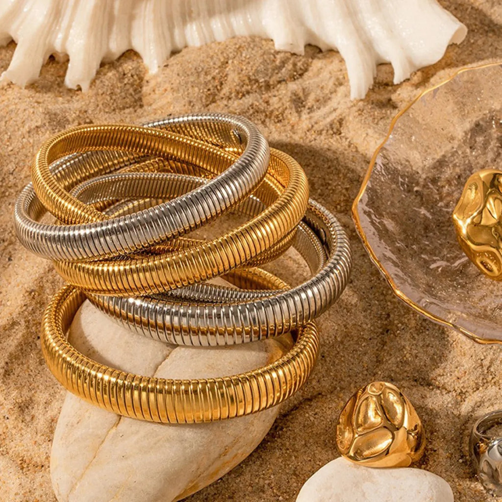 Gold titanium steel women's bracelet with elastic band and vertical stripe ring pattern, shown at 2cm width.