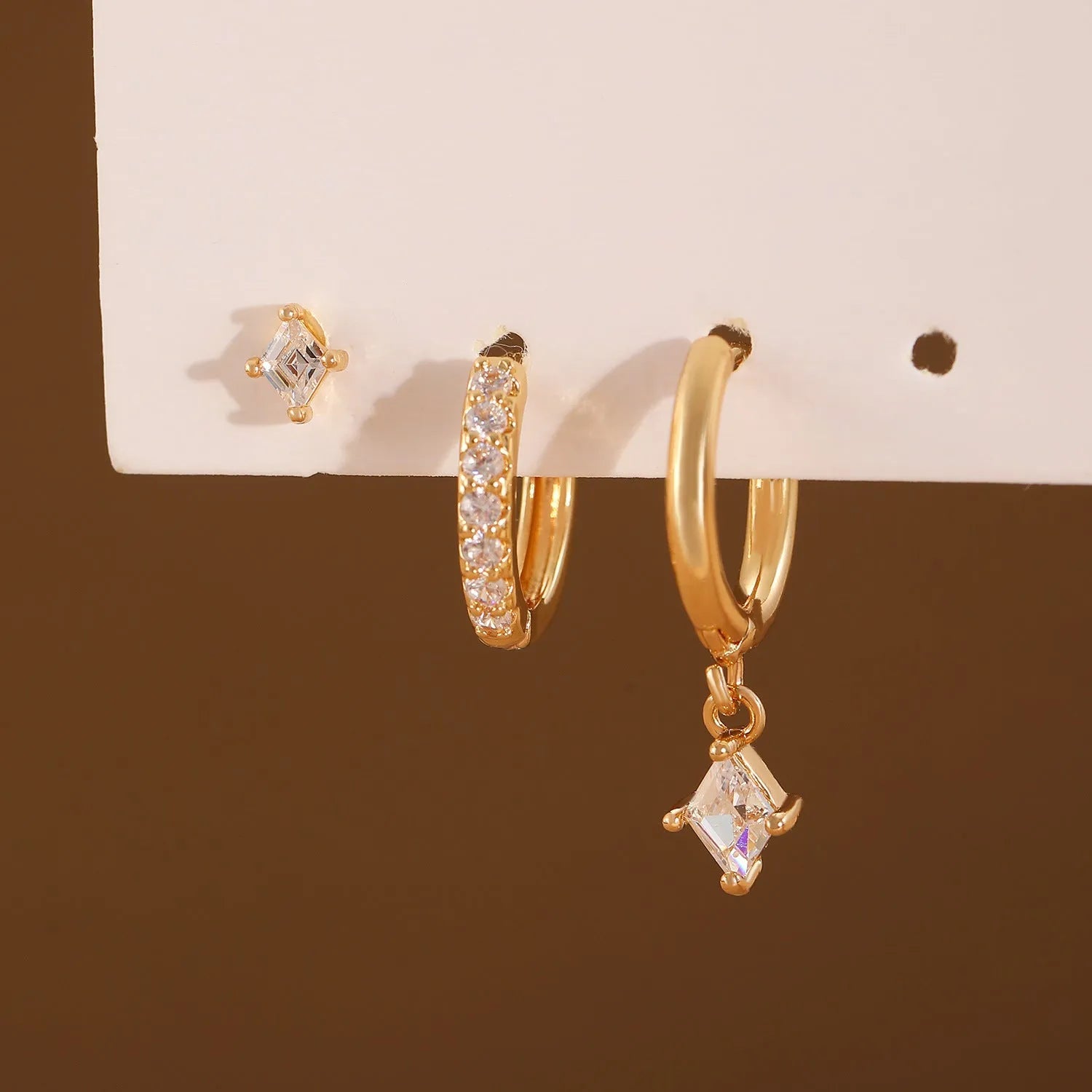 Ladies three-piece earring set with geometric designs and zircon accents in gold or white finish