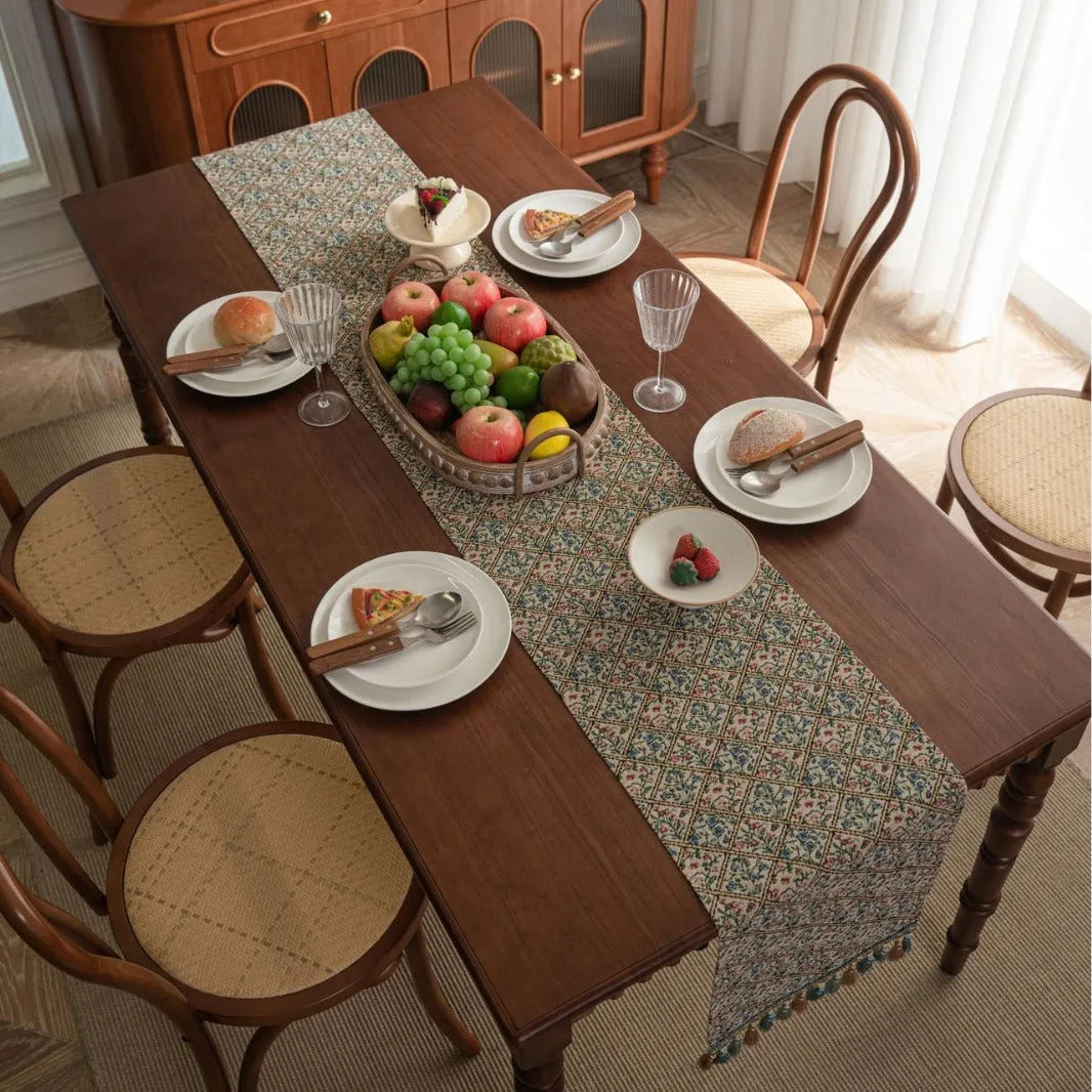 Dark blue Nordic Jacquard table runner with bouquet design and tassels laid on a wooden table.
